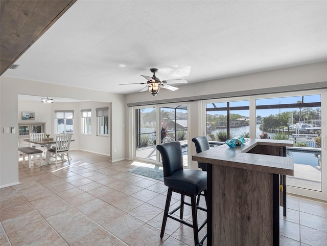 6604 Dolphin Cove Dr, Apollo Beach, FL 33572 - dining space featuring a water view, baseboards, ceiling fan, and light tile patterned flooring
