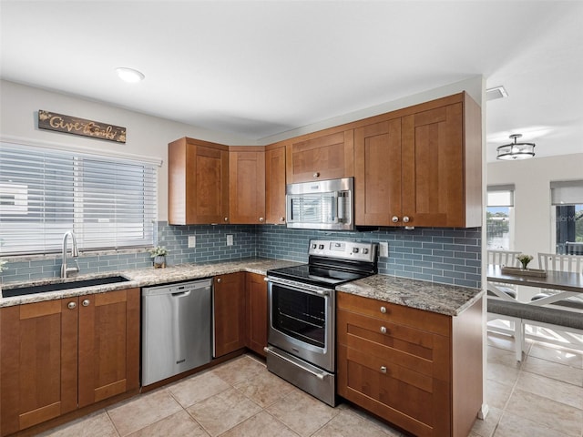 6604 Dolphin Cove Dr, Apollo Beach, FL 33572 - kitchen featuring appliances with stainless steel finishes, a sink, brown cabinets, and backsplash