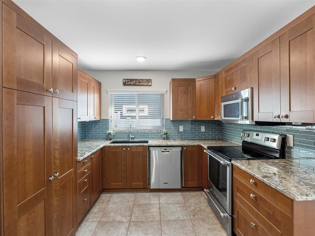 6604 Dolphin Cove Dr, Apollo Beach, FL 33572 - kitchen with appliances with stainless steel finishes, a sink, tasteful backsplash, and brown cabinets