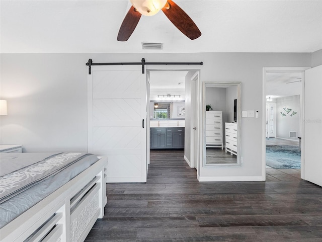6604 Dolphin Cove Dr, Apollo Beach, FL 33572 - bedroom featuring dark wood-style flooring, a barn door, ensuite bathroom, baseboards, and a ceiling fan