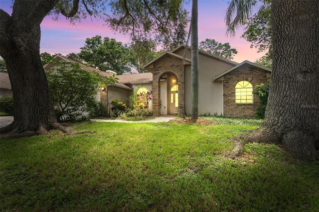 3001 Folklore Dr, Valrico, FL 33596 - view of front of home featuring a yard, stucco siding, and brick siding
