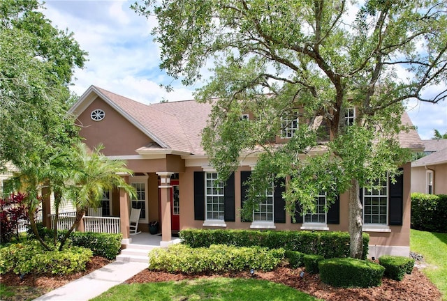 10309 Marchmont Ct, Tampa, FL 33626 - view of front facade with stucco siding, a porch, and a shingled roof