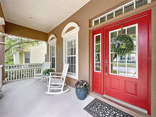 10309 Marchmont Ct, Tampa, FL 33626 - doorway to property featuring covered porch and stucco siding