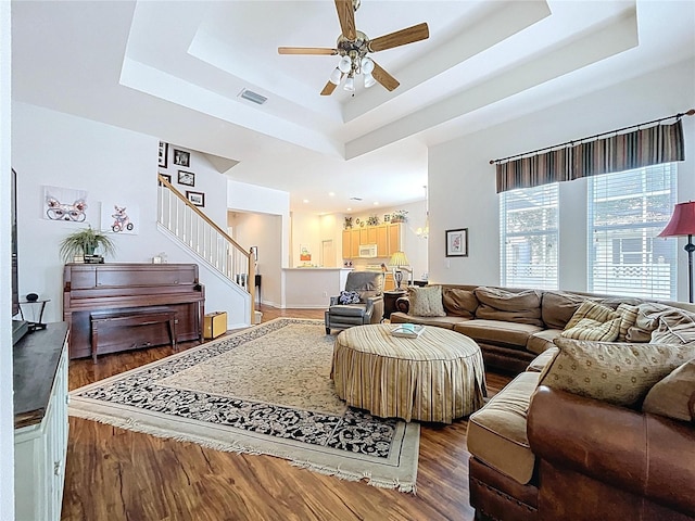 10309 Marchmont Ct, Tampa, FL 33626 - living room featuring a raised ceiling, ceiling fan, wood finished floors, and stairway