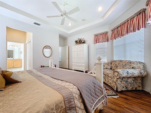 10309 Marchmont Ct, Tampa, FL 33626 - bedroom with wood finished floors, baseboards, a tray ceiling, ensuite bath, and ceiling fan