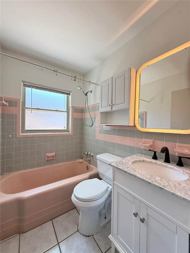 full bath with shower / bathing tub combination, tile walls, tile patterned floors, vanity, and toilet