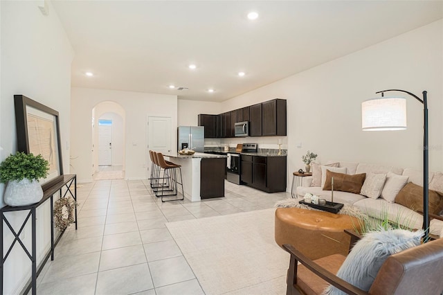 living room featuring arched walkways, recessed lighting, and light tile patterned flooring
