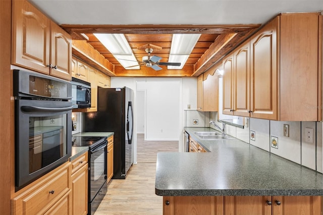 6365 32nd Ave N, Saint Petersburg, FL 33710 - kitchen featuring a sink, black appliances, light wood-style flooring, dark countertops, and ceiling fan