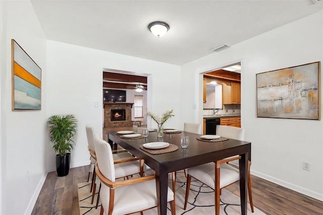 6365 32nd Ave N, Saint Petersburg, FL 33710 - dining space featuring ceiling fan, wood finished floors, a lit fireplace, and baseboards