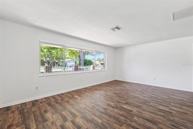 6365 32nd Ave N, Saint Petersburg, FL 33710 - empty room featuring dark wood-style flooring, a textured ceiling, and baseboards