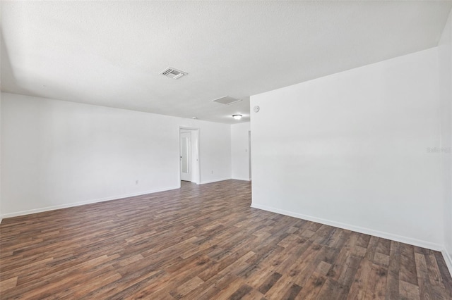 6365 32nd Ave N, Saint Petersburg, FL 33710 - unfurnished room featuring dark wood-type flooring, baseboards, attic access, and a textured ceiling