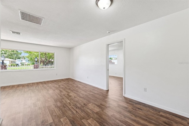 6365 32nd Ave N, Saint Petersburg, FL 33710 - empty room with wood finished floors, a textured ceiling, and baseboards