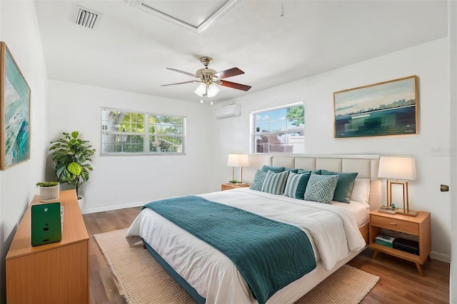 6365 32nd Ave N, Saint Petersburg, FL 33710 - bedroom featuring wood finished floors, a wall unit AC, baseboards, and attic access