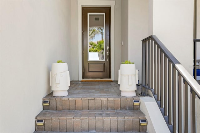 doorway to property with visible vents and stucco siding