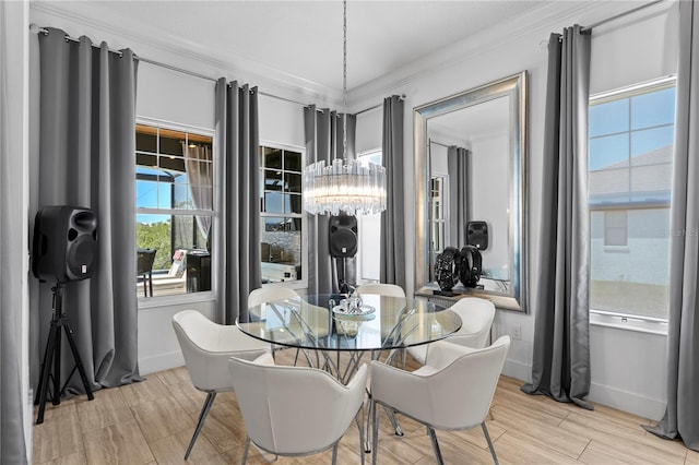 dining space with crown molding, baseboards, a chandelier, and wood tiled floor