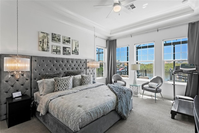 bedroom featuring crown molding, a raised ceiling, multiple windows, and carpet flooring