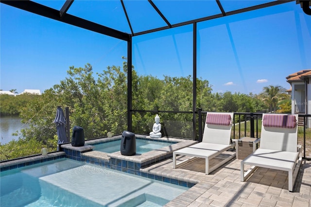 outdoor pool with a water view, an in ground hot tub, a lanai, and a patio area