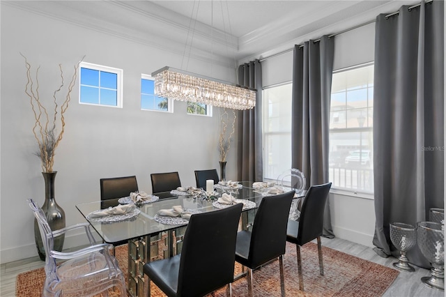 dining space featuring crown molding, baseboards, wood finished floors, and an inviting chandelier