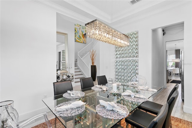dining room featuring stairs, a chandelier, ornamental molding, and visible vents