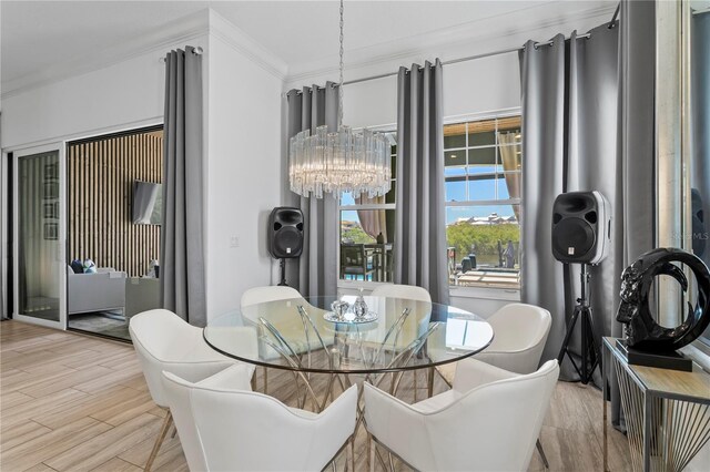 dining room featuring an inviting chandelier, ornamental molding, and light wood finished floors