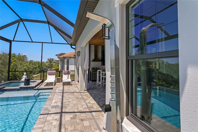 view of pool with glass enclosure, a patio area, and a pool with connected hot tub