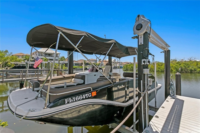 dock area with boat lift and a water view
