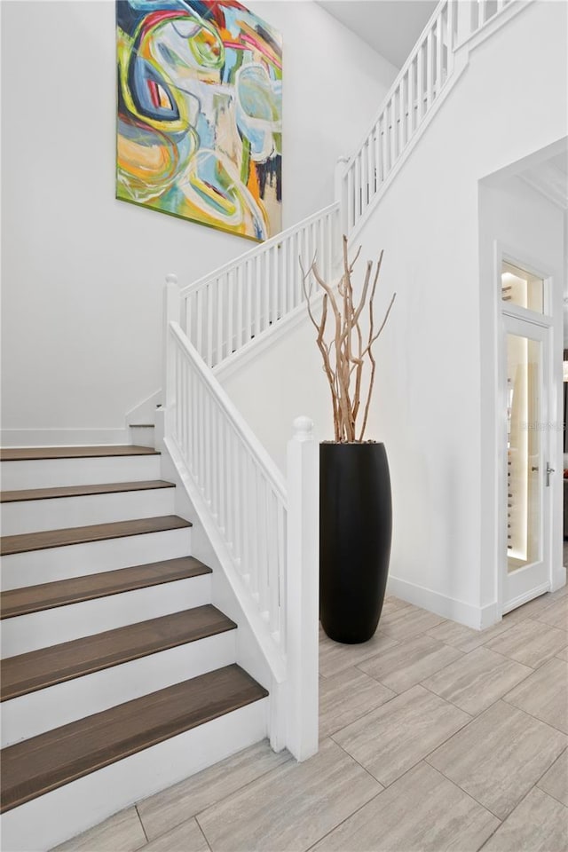 staircase with baseboards and wood finished floors