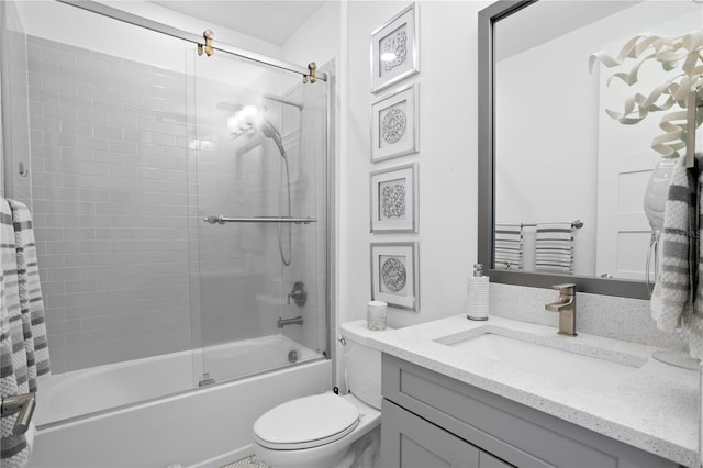 bathroom featuring toilet, shower / bath combination with glass door, and vanity
