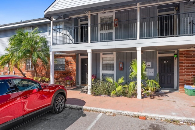 200 Country Club Dr Unit 906, Largo, FL 33771 - view of front of home featuring a balcony, board and batten siding, and brick siding