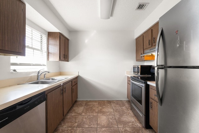 200 Country Club Dr Unit 906, Largo, FL 33771 - kitchen with visible vents, light countertops, under cabinet range hood, a sink, and appliances with stainless steel finishes