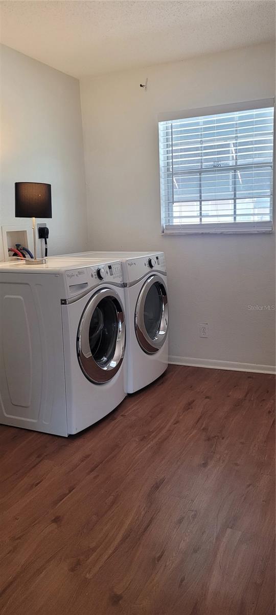 200 Country Club Dr Unit 906, Largo, FL 33771 - clothes washing area featuring washing machine and clothes dryer, laundry area, a textured ceiling, baseboards, and wood finished floors