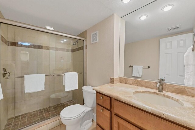 full bath with visible vents, a shower stall, toilet, and vanity