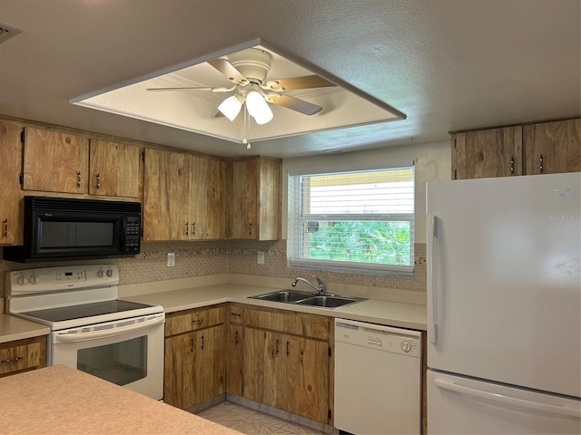 kitchen with white appliances, a sink, light countertops, and decorative backsplash