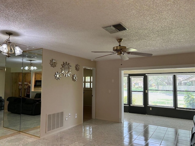 spare room with ceiling fan, a textured ceiling, baseboards, and a chandelier