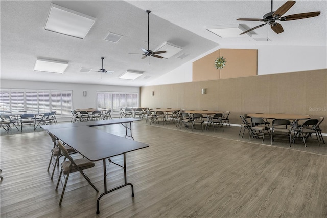 recreation room with high vaulted ceiling, a textured ceiling, wood finished floors, and ceiling fan