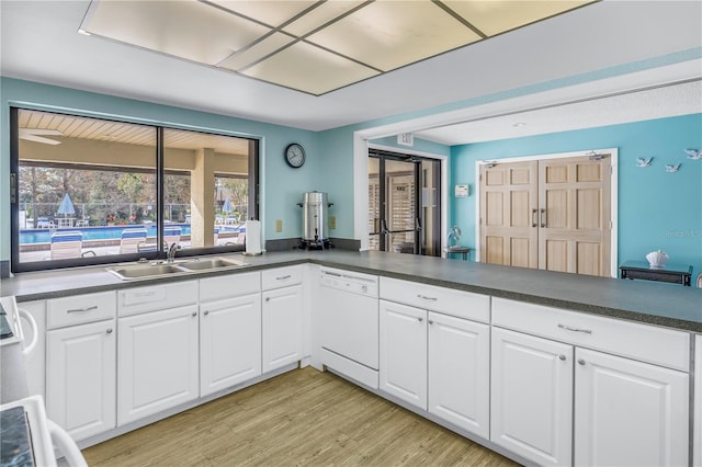 kitchen featuring dishwasher, a sink, light wood-style flooring, and white cabinets