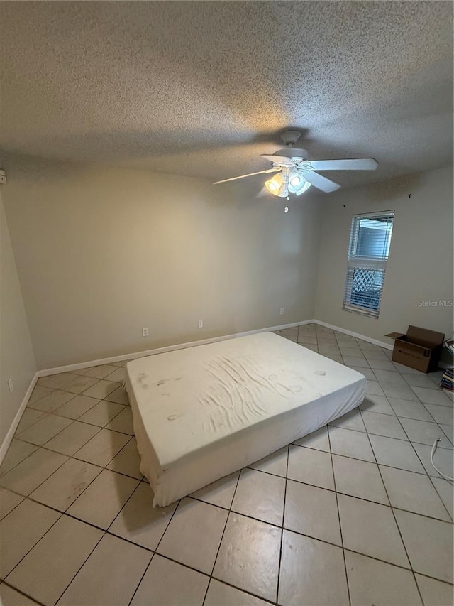 7360 Ulmerton Rd Unit 20F, Largo, FL 33771 - bedroom featuring light tile patterned flooring, a textured ceiling, ceiling fan, and baseboards