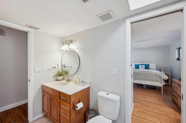 6514 Sunhigh Dr, New Port Richey, FL 34655 - bathroom featuring wood finished floors, toilet, vanity, connected bathroom, and baseboards
