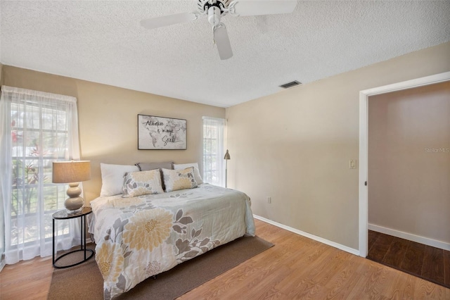 6514 Sunhigh Dr, New Port Richey, FL 34655 - bedroom with wood finished floors, a textured ceiling, baseboards, and ceiling fan