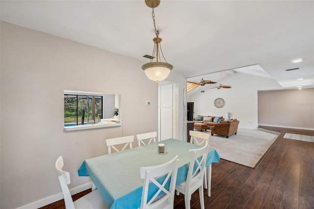 6514 Sunhigh Dr, New Port Richey, FL 34655 - dining area with dark wood-type flooring, baseboards, and vaulted ceiling