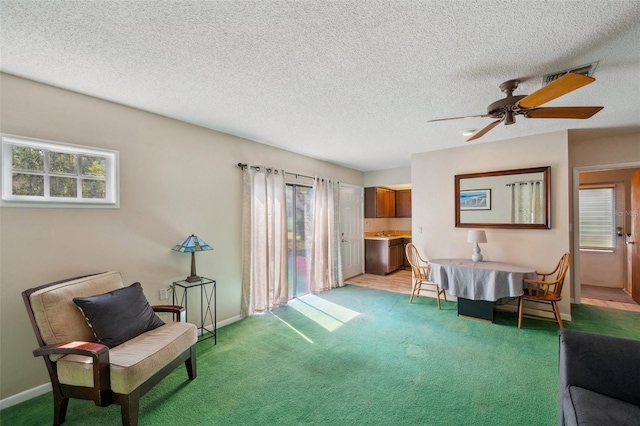 6514 Sunhigh Dr, New Port Richey, FL 34655 - sitting room with healthy amount of natural light, light colored carpet, ceiling fan, baseboards, and a textured ceiling