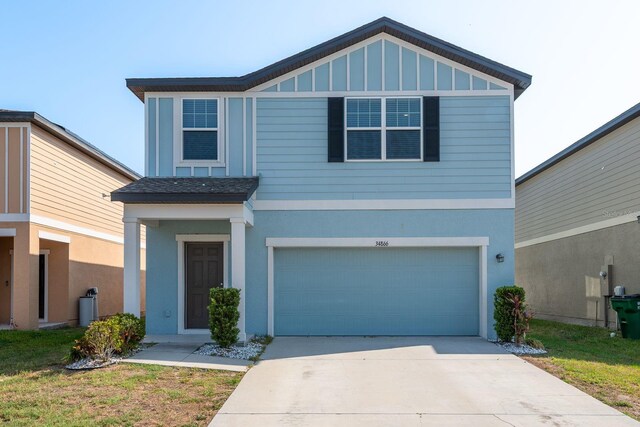 view of front facade with a garage, concrete driveway, stucco siding, and board and batten siding