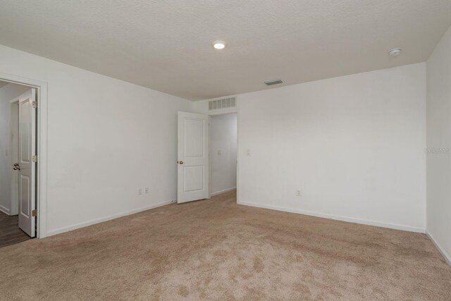 carpeted empty room featuring baseboards and a smoke detector