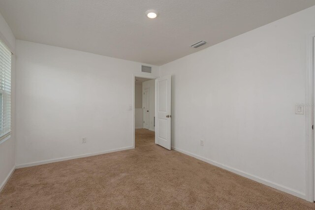 carpeted empty room featuring baseboards
