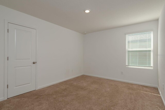 carpeted empty room featuring baseboards