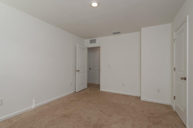 unfurnished bedroom featuring light colored carpet and baseboards