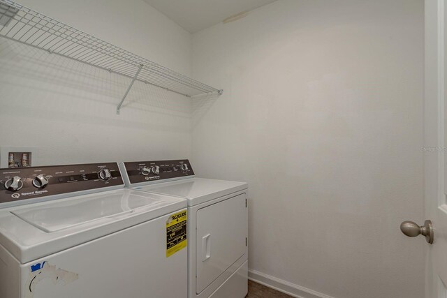 laundry room featuring washing machine and dryer and baseboards