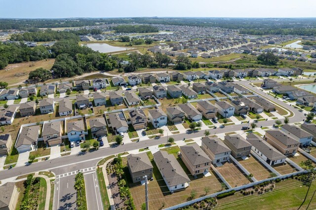 aerial view of property's location featuring a nearby body of water and nearby suburban area