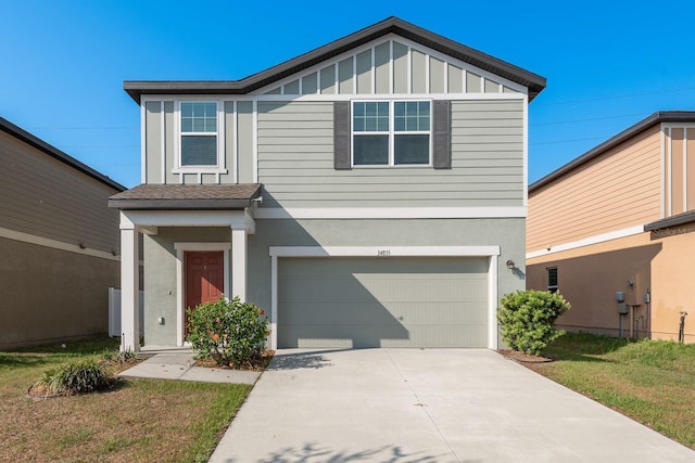 view of front of house featuring an attached garage, concrete driveway, stucco siding, and a front lawn