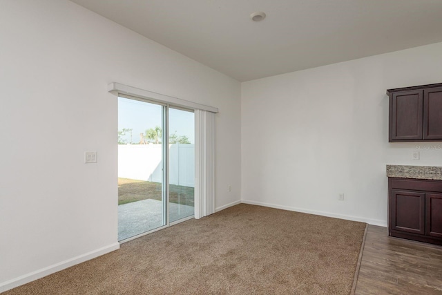 unfurnished living room with baseboards and dark wood-style floors